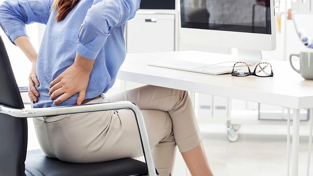 lower back pain woman sitting on a desk